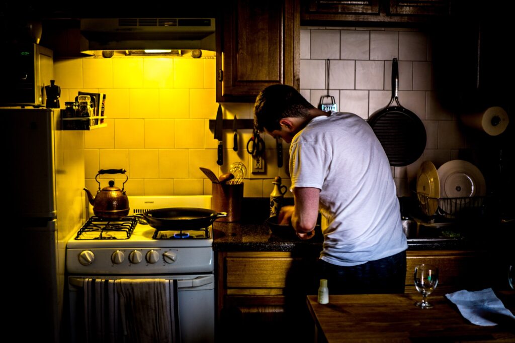 Mann in dunkler Küche wegen schlechter Beleuchtung