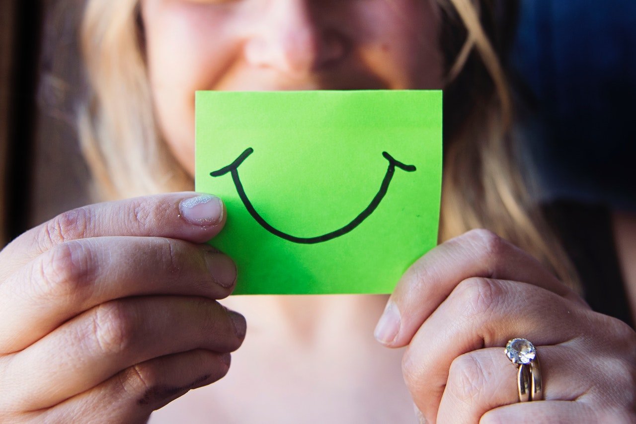 Woman holding paper with a smiley face