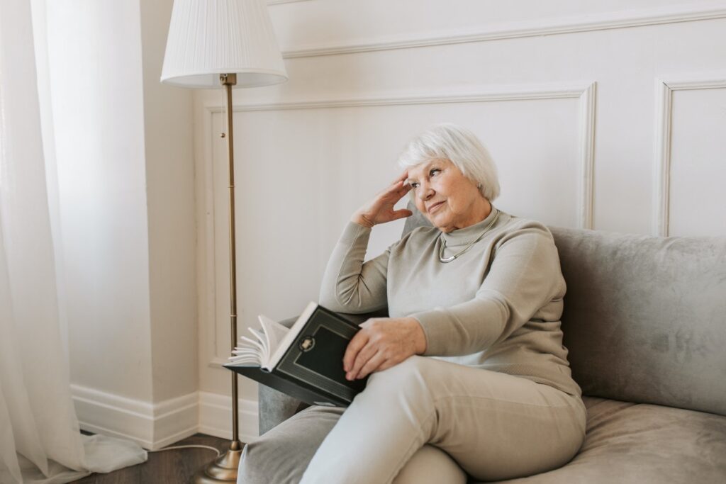 Old lady sitting on sofa with a floor lamp
