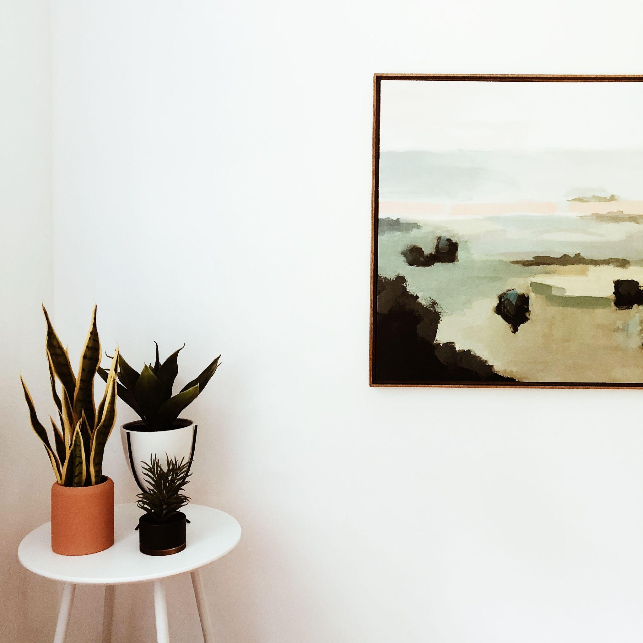 a minimalist painting and table with plant