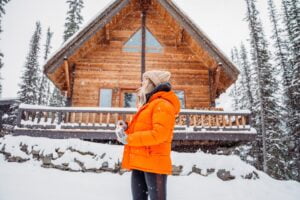 Woman standing in front ouf house in winter